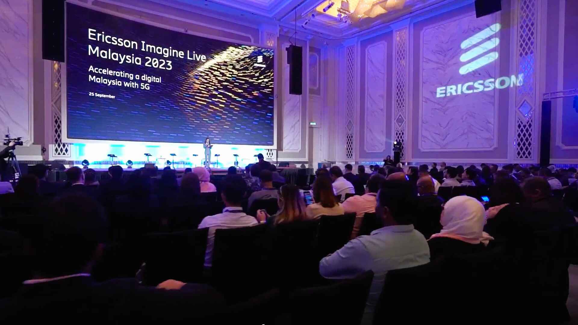 Ericsson Imagine Live Malaysia 2023 attendees in a packed hall watching a speaker presentation.