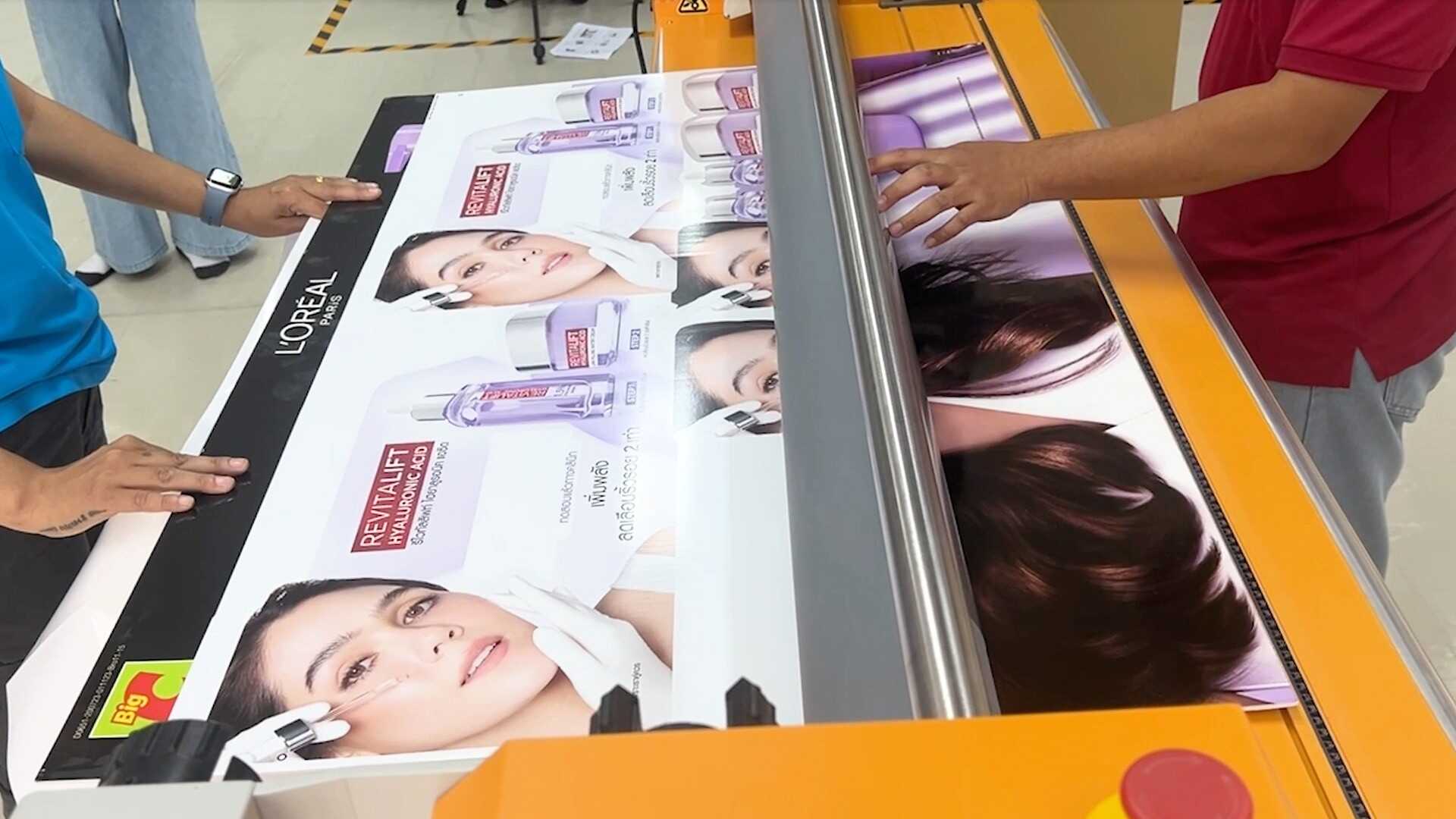 Two men are engaged in a project, working together on a large print spread out before them.