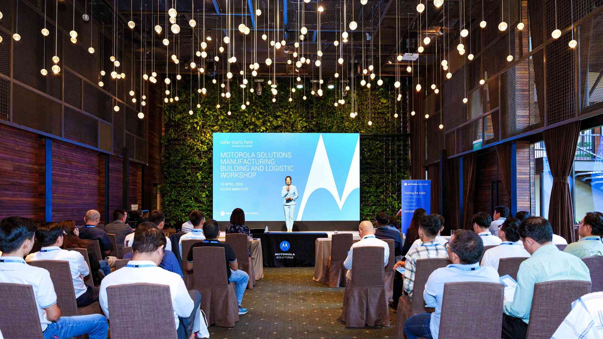 A large conference room with seated Motorola Workshop attendees viewing a speaker presentation.