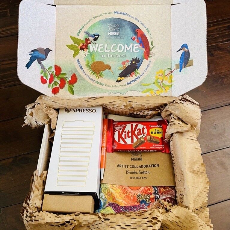 A Nestlé welcome box filled with assorted items, including snacks and stationery.