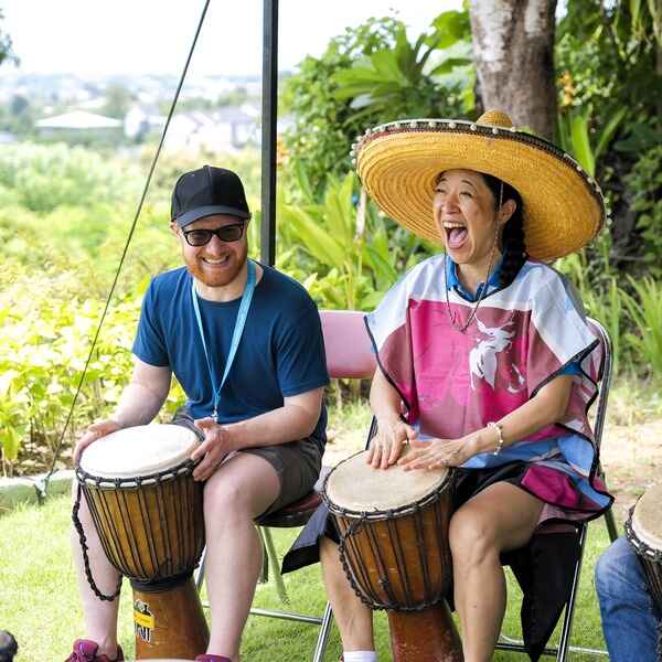 Philips APAC Connect 2024 attendees playing drums and enjoying a lively outdoor activity.