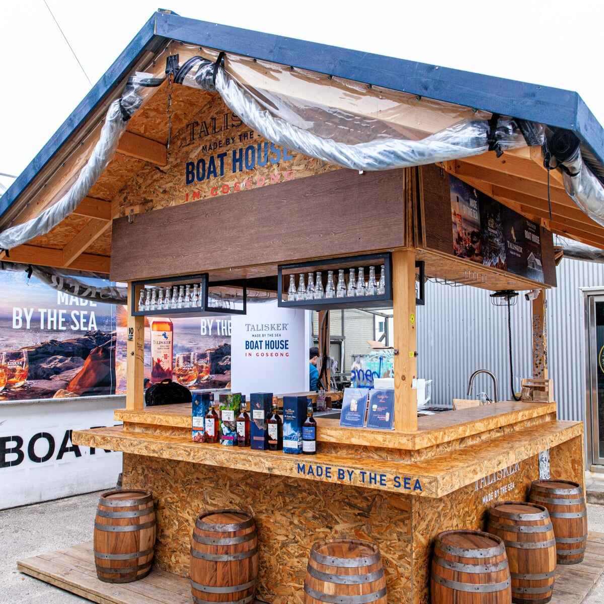 A rustic bar with wooden countertops and barrels, perfect for socializing and relaxation.